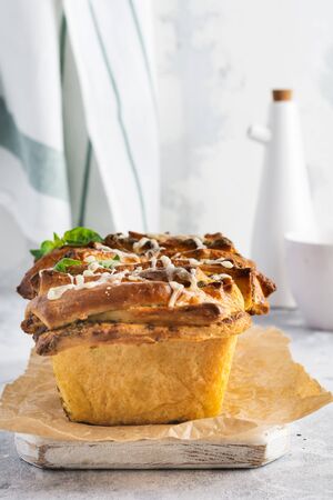 Pull-apart bread with Italian pasta pesto, basil and parmesan cheese in baking form over old light concrete background. Top view. Rustic stile.の写真素材
