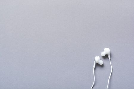 Modern White headphones on a gray background. Minimalist style. Top view with copy space.の写真素材