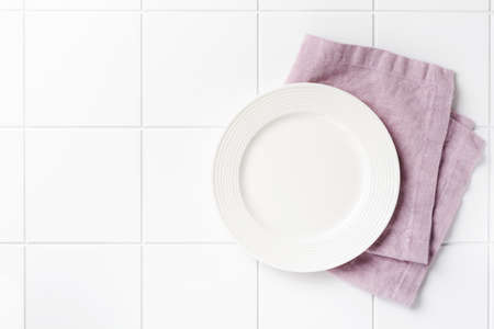 White plate, cutlery and napkin on stone table top view. Table setting.