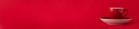 Red ceramic empty cup for espresso coffee on red background. Space for text. Banner.の写真素材