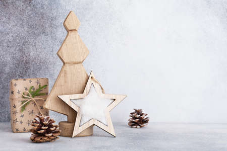 Decorative wooden Christmas tree and star, cone and fabric wrapped gifts, on a light background. Zero waste concept.の写真素材