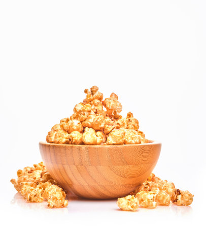 Delicious sweet popcorn with caramel in wooden bowl, isolated on white background.の写真素材