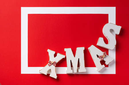 Christmas festive background. White frame with red Christmas decorations on red background. Place for text. Top view.の写真素材