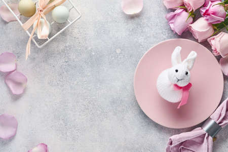 Easter table setting with floral decor on gray table. Elegance dinner. Mock up. Top view.