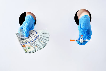 syringe with vaccine and banknotes in protective medical blue gloves in hand through white paper...