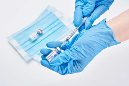 hand in blue gloves holding vaccine disease preparing for human clinical trials vaccination shot, medicine and drug concept.の写真素材