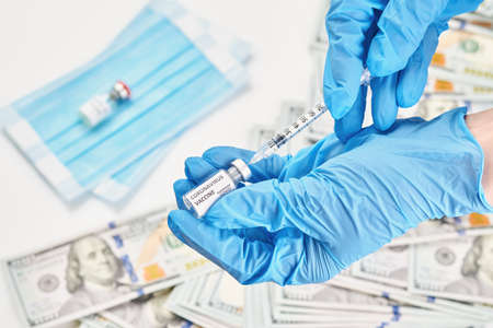 hand in blue gloves holding vaccine disease preparing for human clinical trials vaccination shot,...