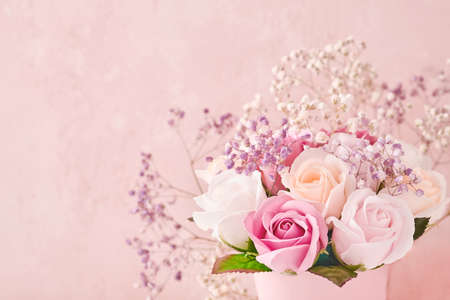 Festive composition with beautiful delicate roses flowers in pink round box on light pink background. Flat lay, copy space. Greeting card.の写真素材