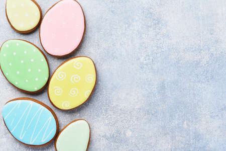 Easter multicolored gingerbread, candy and scattered confectionery topping dressing on gray background. Easter baking background. Celebratory background concept. Space for text.の写真素材