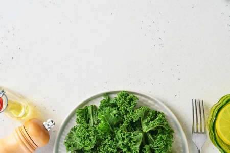 Bowl of fresh green chopped kale on light gray stone background, top view. Ingredient for making healthy salad. Clean eating, detox or diet concept. Mock up.の写真素材