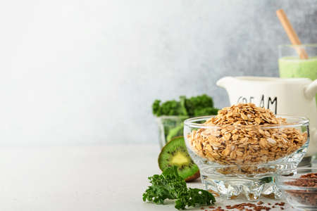 Oatmeal, kale, kiwi and chia seeds, cream ingredients for making detox smoothies on gray light...