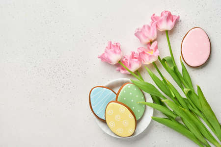 Easter table setting with floral decor and plate with easter gingerbread on gray table. Elegance dinner. Mock up. Top view.の写真素材