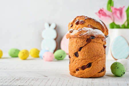 Easter cake, bright eggs, gingerbread and pussy willows branches on a festive Easter table. Greeting...