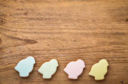Easter composition with easter chickens cookies gingerbread on wooden background. Festive concept or greeting card with copy space. Flat lay, top view.の写真素材