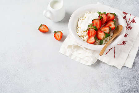 Cottage cheese, curd cheese with strawberries berries in a bowl, ogranic homemade dairy product. Healthy dairy product rich in Calcium and Protein.の写真素材