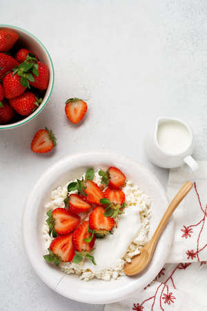 Cottage cheese, curd cheese with strawberries berries in a bowl, ogranic homemade dairy product. Healthy dairy product rich in Calcium and Protein.の写真素材