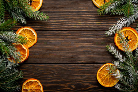 Christmas or New Year background. Fir branches with dried orange, cardamom and mulled wine spices, sprinkledon dark wooden background. Place for your textの写真素材