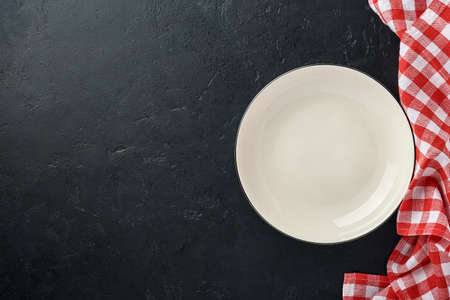 Kitchen table with empty plate white color, red tablecloth and space for your recipe or menu. Top view. Mock up.の写真素材