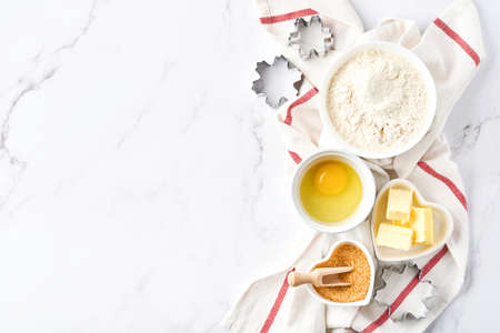 Baking background with flour, eggs, kitchen tools, utensils and cookie molds on white marble table. Top view. Flat lay style. Mock up.の写真素材