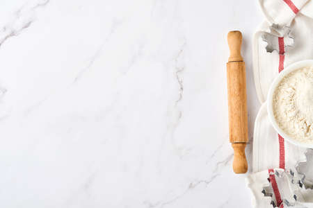 Baking background with flour, eggs, kitchen tools, utensils and cookie molds on white marble table. Top view. Flat lay style. Mock up.の写真素材