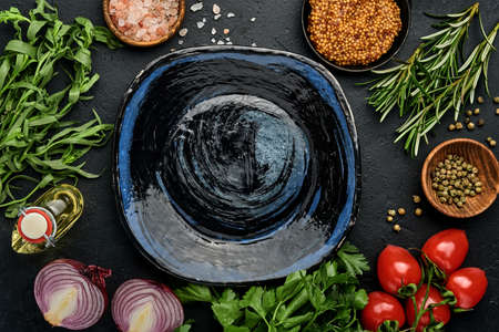 Fresh tarragon. Branch of fresh herb seasoning and cooking products, tomatoes, peppers, onions and olive oil on black concrete background. Cooking Background. Top view.の写真素材