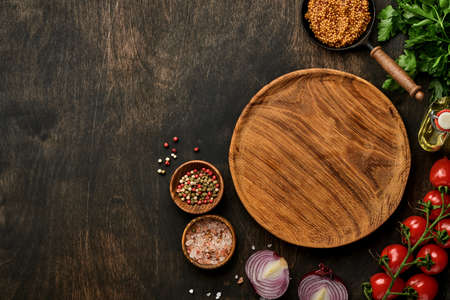 Fresh tarragon. Branch of fresh herb seasoning and cooking products, tomatoes, peppers, onions and olive oil on black concrete background. Cooking Background. Top view.の写真素材