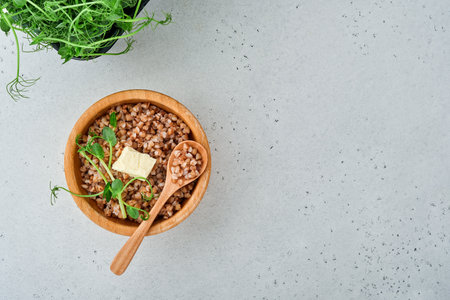 Buckwheat porridge in bowl with parsley leaf and butter on gray stone background. Gluten free ancient grain for healthy diet. Top view. Copy space.の写真素材