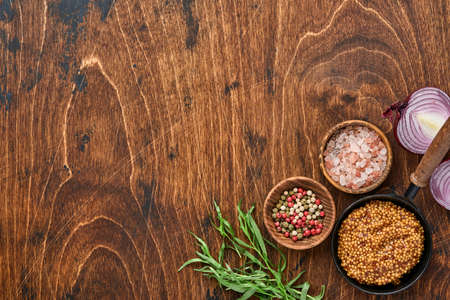 Fresh tarragon. Branch of fresh herb seasoning and cooking products, tomatoes, peppers, onions and olive oil on black concrete background. Cooking Background. Top view.の写真素材
