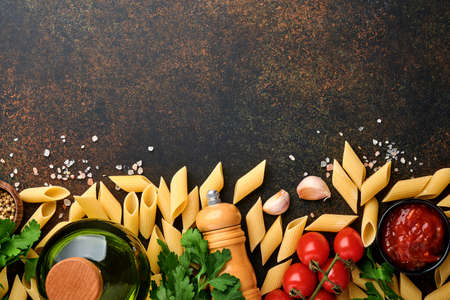 Pasta background. Pasta rigati, tomato ketchup sauce, olive oil, spices, parsley, and fresh tomatoes...