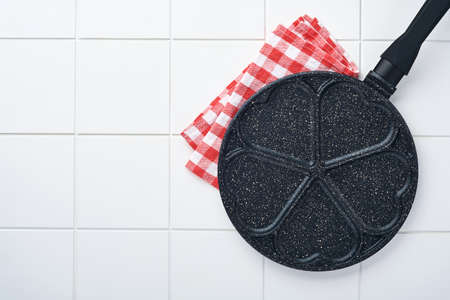 Empty frying pan black, skillet with stone nonstick coating for baking pancakes in shape of breakfast hearts and ingredients on gray concrete table background. Breakfast for Valentines Day. Top view.の写真素材