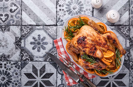 Roasted or baked whole chicken with rosemary and oranges, homemade for Christmas traditional family...