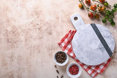 Fresh cherry tomato branches, napkin, red and black pepper on white marble stand background. Food...