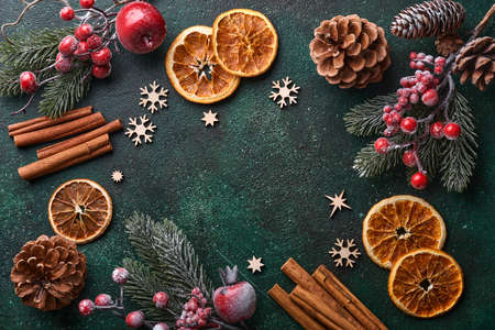 Christmas fir tree branches, Christmas balls, gift box, wooden snowflakes and stars on green concrete stone background for your xmas greetings. Top view with copy space. Christmas greeting card.の写真素材