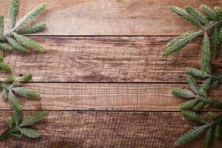 Christmas or New Year background with fir branches on the right and left side on dark wooden background. Place for your textの写真素材