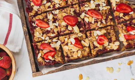 Homemade oat crumble bars with strawberries, on light concrete background. Rustik style. Top viewの写真素材