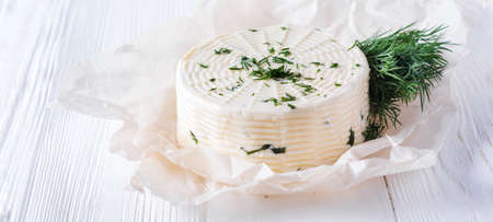 Pickled cheese with dill, spices and garlic on a white wooden background. Selective focusの写真素材