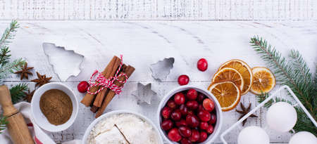 Ingredients for the preparation of homemade Christmas baking cranberries, flour, cinnamon, eggs and seasoning anise on a light wooden background. Top view.の写真素材