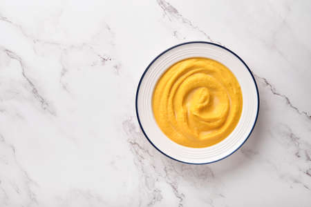 Pumpkin traditional soup with creamy silky texture with sage leaves and red pepper in white plate or bowl. Light gray background. Copy space. Mock up. Top view, flat lay.の写真素材