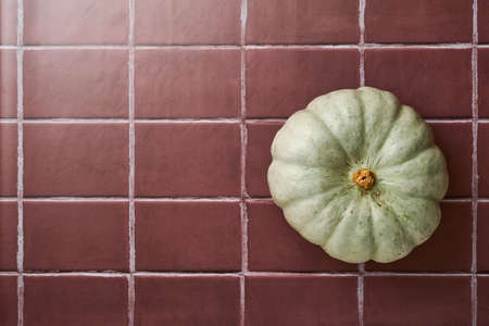 Pumpkin. Autumn food background with cinnamon, nuts and seasonal spices on old ceramic tiles background. Cooking pumpkin or apple pie and cookies for Thanksgiving and autumn holidays. Top view.の写真素材