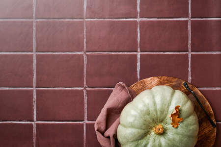Pumpkin. Autumn food background with cinnamon, nuts and seasonal spices on old ceramic tiles background. Cooking pumpkin or apple pie and cookies for Thanksgiving and autumn holidays. Top view.の写真素材