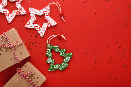 Christmas presents box. New Year or Christmas flat lay top view Xmas holiday celebration decoration red paper background with copyspace. Template mockup greeting card text designの写真素材