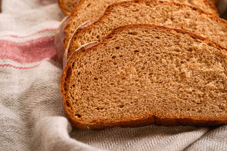 Fresh homemade rye bread. Traditional spelled sourdough bread cut into slices on a rustic wooden...