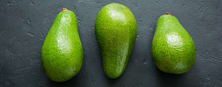 Raw fresh avocado on dark old concrete or stone background. Selective focus. Top view.の写真素材