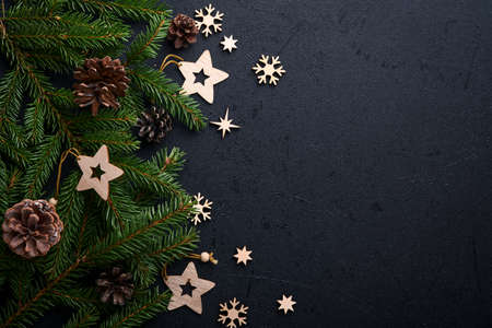 Christmas Decoration. Holiday Decorations with baubles, fir branches and present on dark black...
