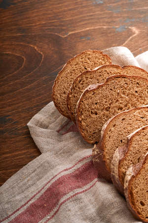Fresh homemade rye bread. Traditional spelled sourdough bread cut into slices on a rustic wooden...