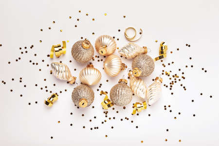 Christmas composition. Christmas gold gift or present box, gold baubles and confetti on white...