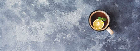Cup of hot Ginger tea with lemon and honey on dark gray background. Top view. Copy space.の写真素材