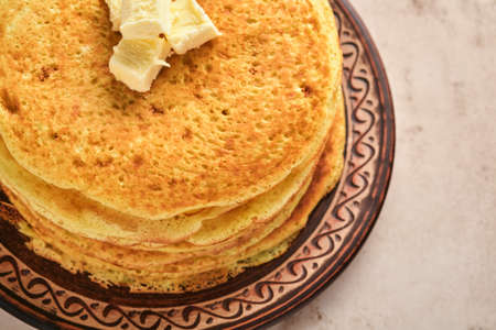 Crepes or thin pancakes stack with butter and red caviar on beautiful ceramic plate on an old brown...