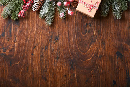 Christmas fir tree branches, Christmas balls, gift box, wooden snowflakes and stars on old wooden background for your xmas greetings. Top view with copy space. Christmas greeting card.の写真素材