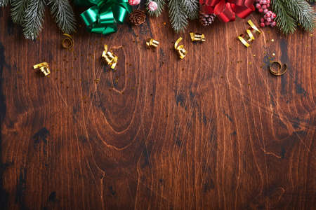 Christmas fir tree branches, Christmas balls, gift box, wooden snowflakes and stars on old wooden background for your xmas greetings. Top view with copy space. Christmas greeting card.の写真素材